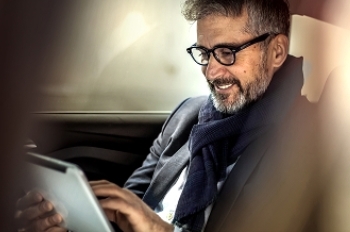 woman sitting at desk using tablet